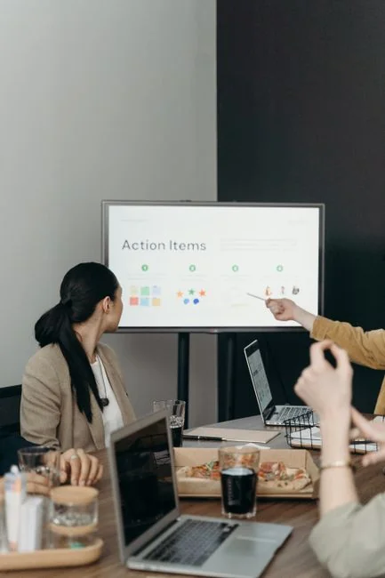 Person analyzes stock data with a smartphone and laptop, indoors.